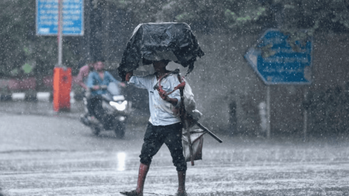 Delhi Weather: दिल्ली में मानसून की बारिश के बीच छतरी लिए चलते लोग, बादलों से ढका आसमान और हल्की फुहारें