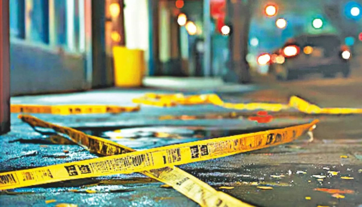 A police officer stands near a crime scene investigation where a murder occurred in Gopalganj, Bihar, as a local watchman was killed by unknown assailants with a knife.