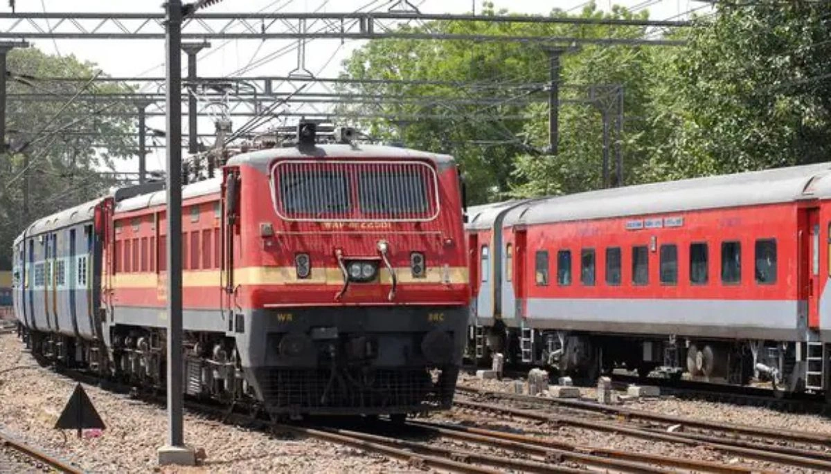 A train on a railway track with passengers boarding at a station, representing the introduction of the Garib Rath Special train service between Saharsa and Anand Vihar.