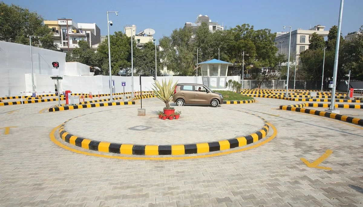 Representation of an automated driving license test track with a car undergoing driving skill assessment on a well-maintained test track.