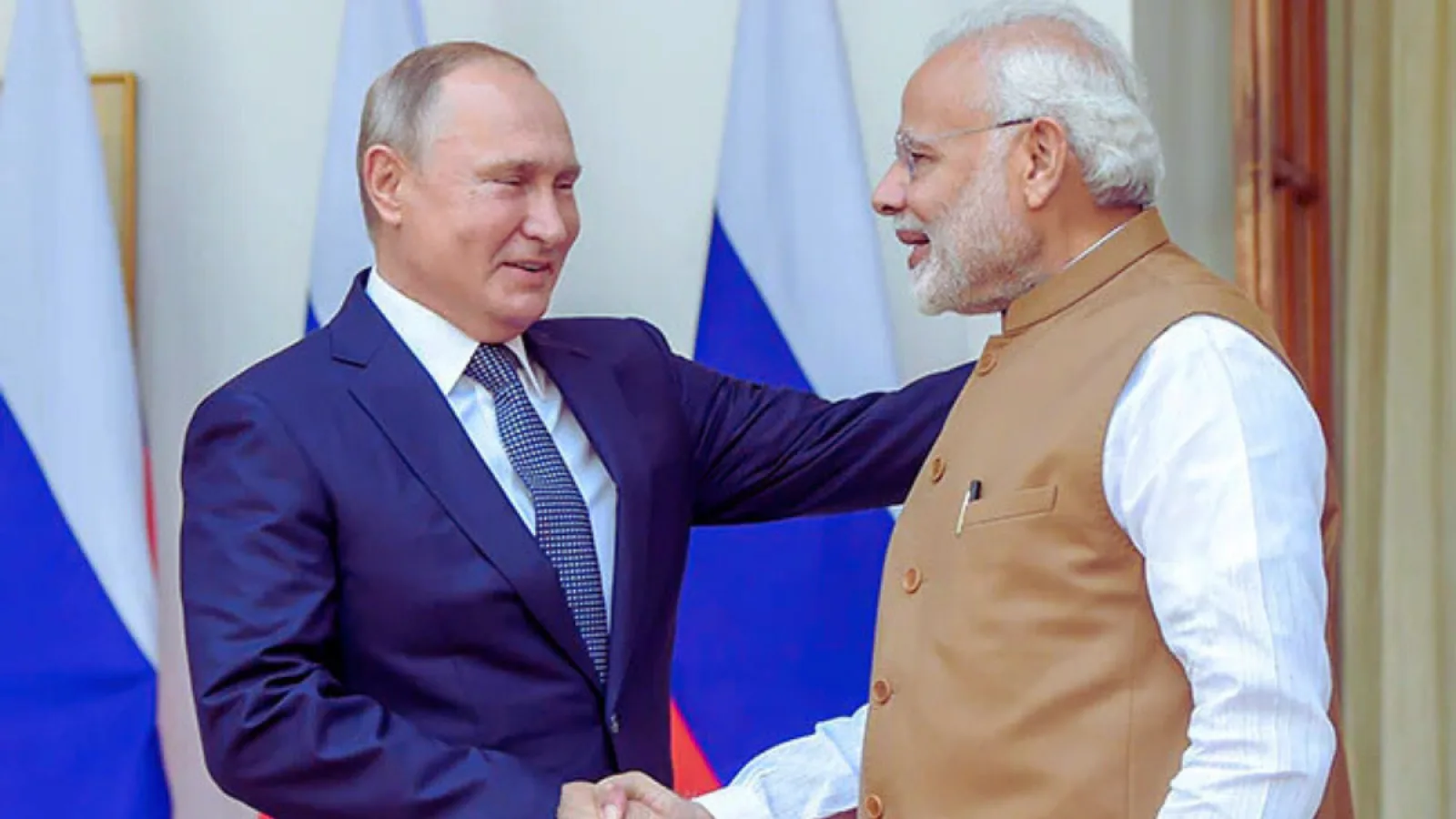 प्रधानमंत्री नरेंद्र मोदी और राष्ट्रपति व्लादिमीर पुतिन एक-दूसरे से गर्मजोशी से मिलते हुए, दोनों नेताओं के बीच भारत-रूस के मजबूत दोस्ताना रिश्तों को दर्शाता चित्र।